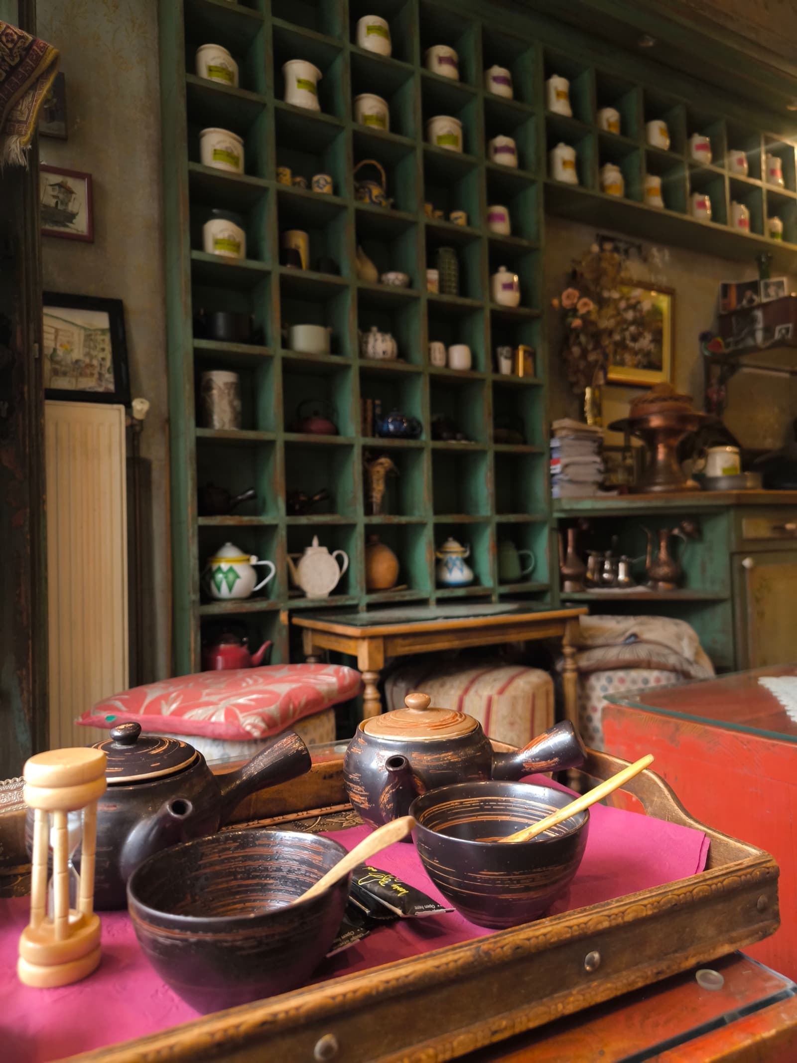 Cozy tea room with shelves of tea tins and a tea tray