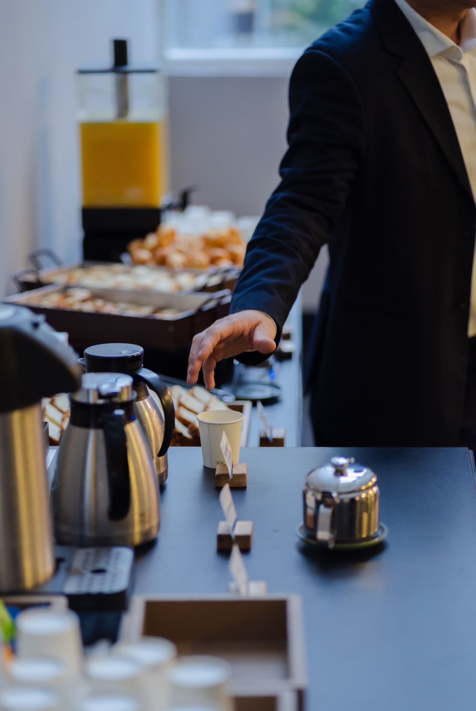 Self-serve tea station with hot water dispensers and paper cups